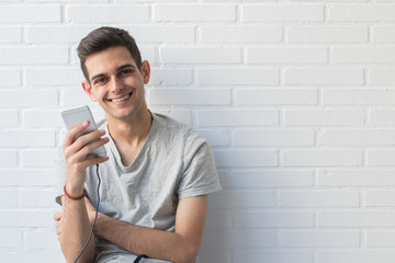 young man or teenager with mobile phone at home
