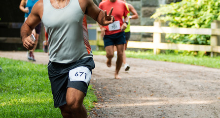 Runner racing in trail giving peace sign to photographer