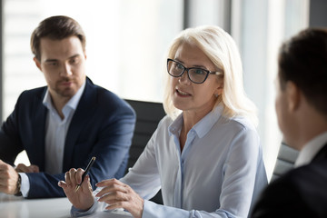 Mature businesswoman talk negotiating with business partners at meeting