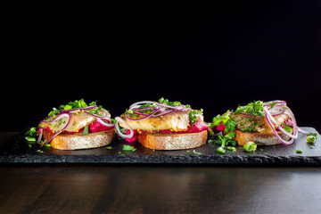 Three smoked salmon sandwich laid out on a black slate-2.