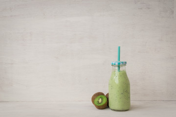 kiwi smoothie in a vintage bottle on a white background with space for copy text