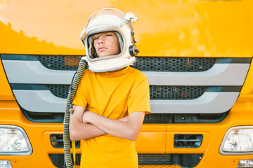 young boy with a helmet in front of a truck