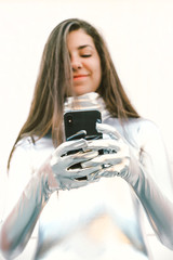 Girl in a silver suit with smartphone