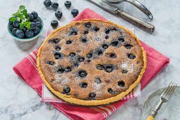 Blueberry and almond tart dusted with icing sugar