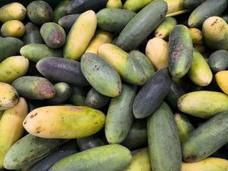 Heap of curuba exotic tropical fruits in a supermarket. Also called banana passionfruit, tumbos or tacos.