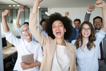 Happy business people celebrating success at company