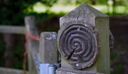 Gate post with a wooden spiral symbol