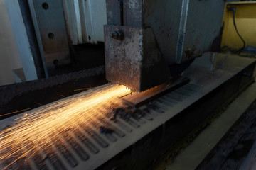 Grinding a metal part on a high-precision surface grinding machine with cooling.