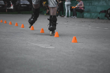 man skates on asphalt and goes round cones