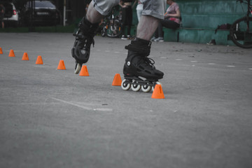 man skates on asphalt and goes round cones