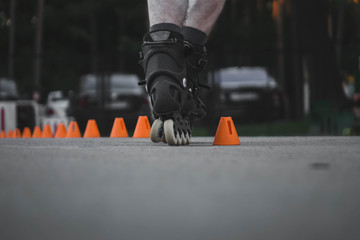 man skates on asphalt and goes round cones