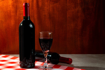 Bottle of red wine in wine cellar for tasting. Red wood background. Wine tradition and culture...