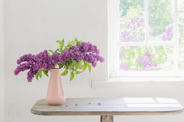 lilac in vase against the window on a sunny day