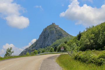 The view on ruins of castle Château de Montségur on the top of mountain from the auto road.