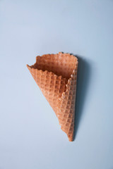 the empty waffle cone on a blue background