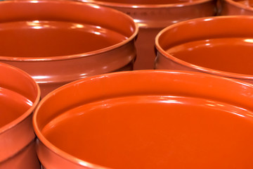Empty metal barrels for storage and transportation of orange juice in the warehouse of canning...