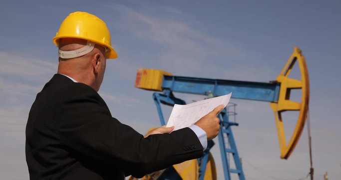 Businessman in with Technical Plan in Hands Inspecting Oil Extracting Platform