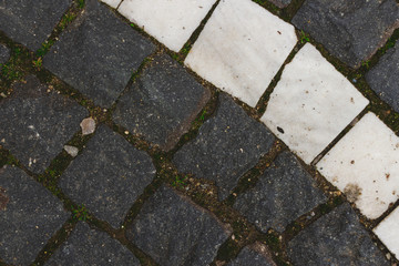 Closeup shot of grey and white square pavement – Rough stone blocks used for decorative purposes in the construction of alleys and sidewalks
