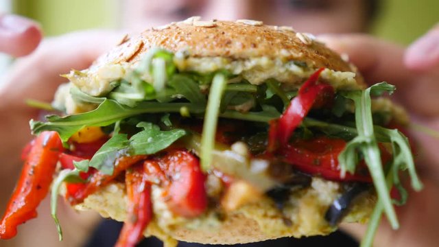 Close Up Of Girl Eating Vegan Bagel Sandwich With Vegetables And Multigrain Bun. Healthy Diet Concept.