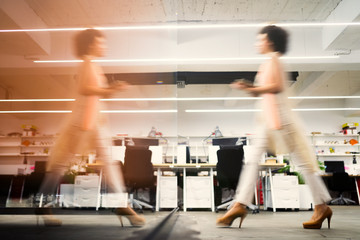 Professional business woman in motion with blur in business office