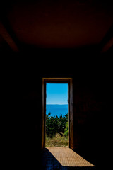 window of an old abandoned building overlooking the sea