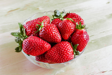 Red ripe garden berry strawberries in deep glass transparent plate, dish, bowl, saucer, bowl, utensils,