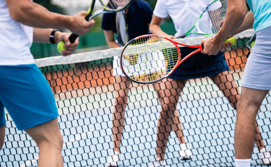 Group of healthy happy friends at the club playing tennis
