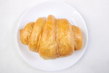 croissant on a white plate on a white table