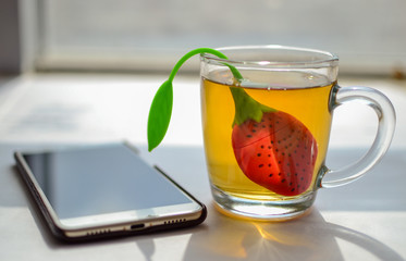 Cup of morning tea and a smartphone on the table