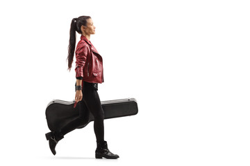 Female musician walking and carrying a guitar in a case