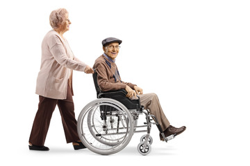 Elderly woman pushing an elderly man in a wheelchair