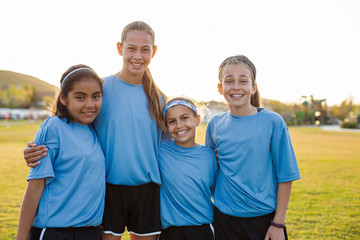 Portrait of smiling girls standing on soccer field against clear sky during sunset © Cavan for Adobe