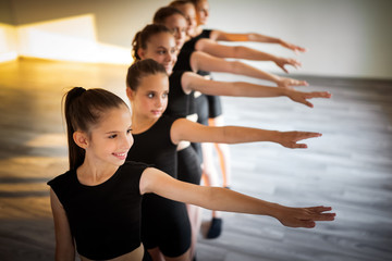 Group of young fit dancers practicing during class school