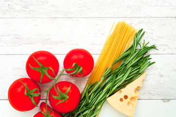 Spaghetti with ingredients on vintage wooden background. The concept of Italian cuisine.