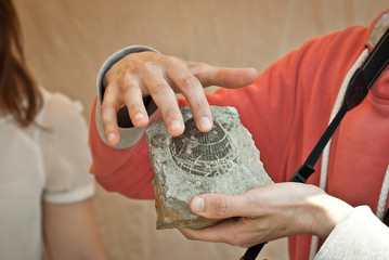 The man touches starchy remains. Demonstration of geological excavations at a scientific conference.