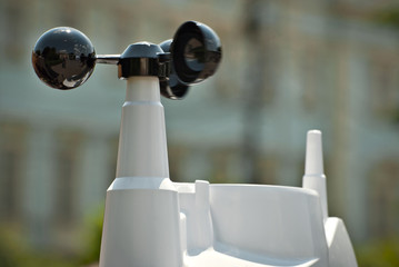 A device that measures speed, force and direction of the wind. White anemometer with solar panels.