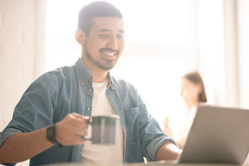 Obraz premium Having tea by laptop