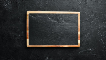 Stone kitchen board. Banner On a black stone background. Top view. Free space for your text.