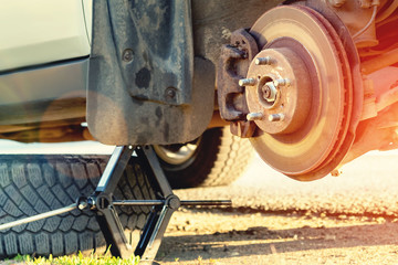 Replacement wheels on the highway, the car is jacked, the wheel is removed, there is a spare wheel