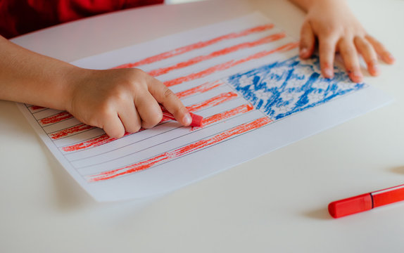 The child draws the flag of America.