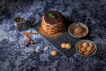 Round tiramisu, homemade no-bake chocolate dessert, traditional Italian sweet food. Table with...