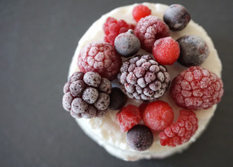 Berries and forest fruit on the top of the white, creamy and tasty cake