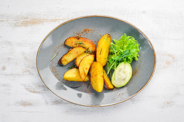 Baked potatoes in a plate. Rustic style. Top view. Free space for your text.