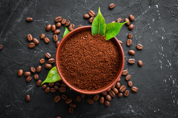Ground coffee and coffee beans. Assortment of coffee varieties on a black background. Top view. Free space for your text.