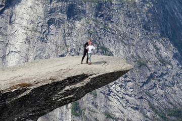 Obraz premium Mother embracing her teen age daughter on Trolltunga rock formation. Jutting cliff is in the Odda, Hordaland county, Norway