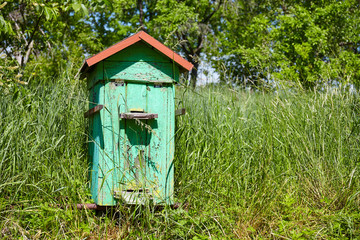 Old wooden beehive in a rural garden.