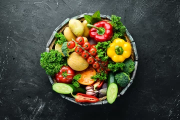  Fresh vegetables and fruits in a wooden box. Avocados, tomatoes, strawberries, melons, potatoes, paprika, citrus. Top view. Free space for your text. © Yaruniv-Studio