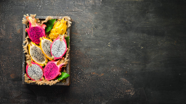 Dragon Fruit in Wooden Box. Pitahaya Tropical Fruits. Top view. Free space for text.