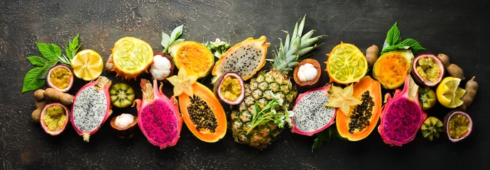 Foto auf Glas Tropische Früchte auf braunem Hintergrund: Papaya, Mangostan, Kaktusfrucht, Pytahaya, Ananas. Ansicht von oben. Freier Platz für Text. © Yaruniv-Studio