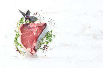 T-bone steak on a white table. Raw Steak Top view. Free space for text.